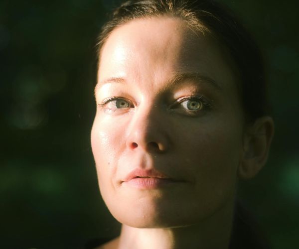 Close-up of a person's serene face with eyes closed, focusing on breathing.
