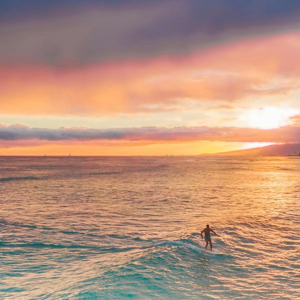 Silhouette of a person meditating against a vibrant sunset.